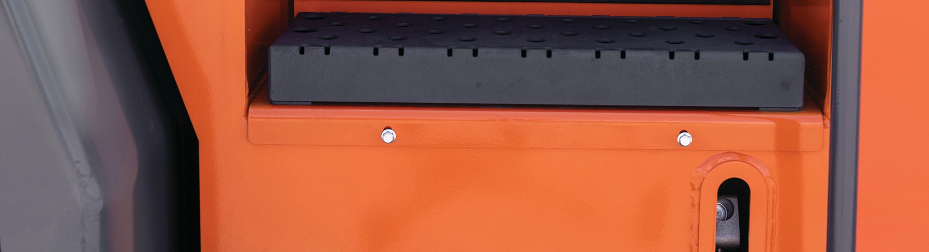 Close-up of orange forklift operator seat backrest with gray padded cushion and mounting hardware
